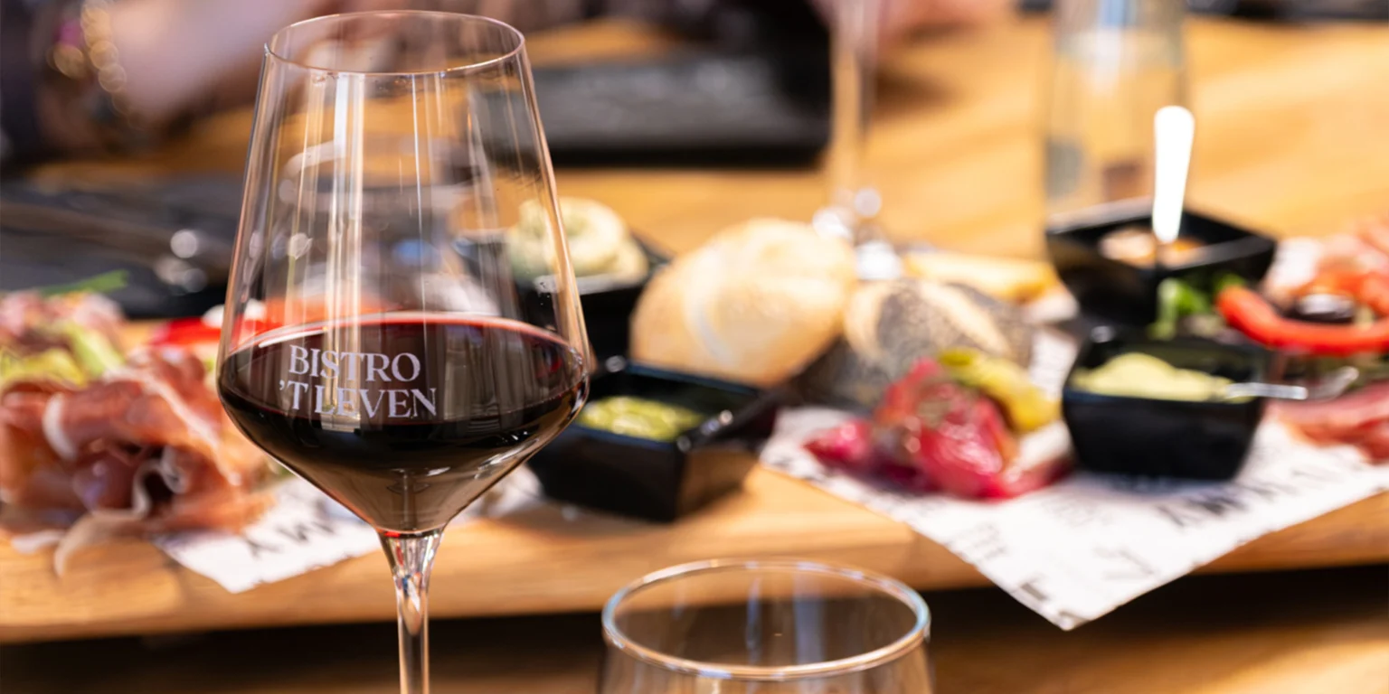 Glas rode wijn bij een gedekte tafel in Bistro 't Leven