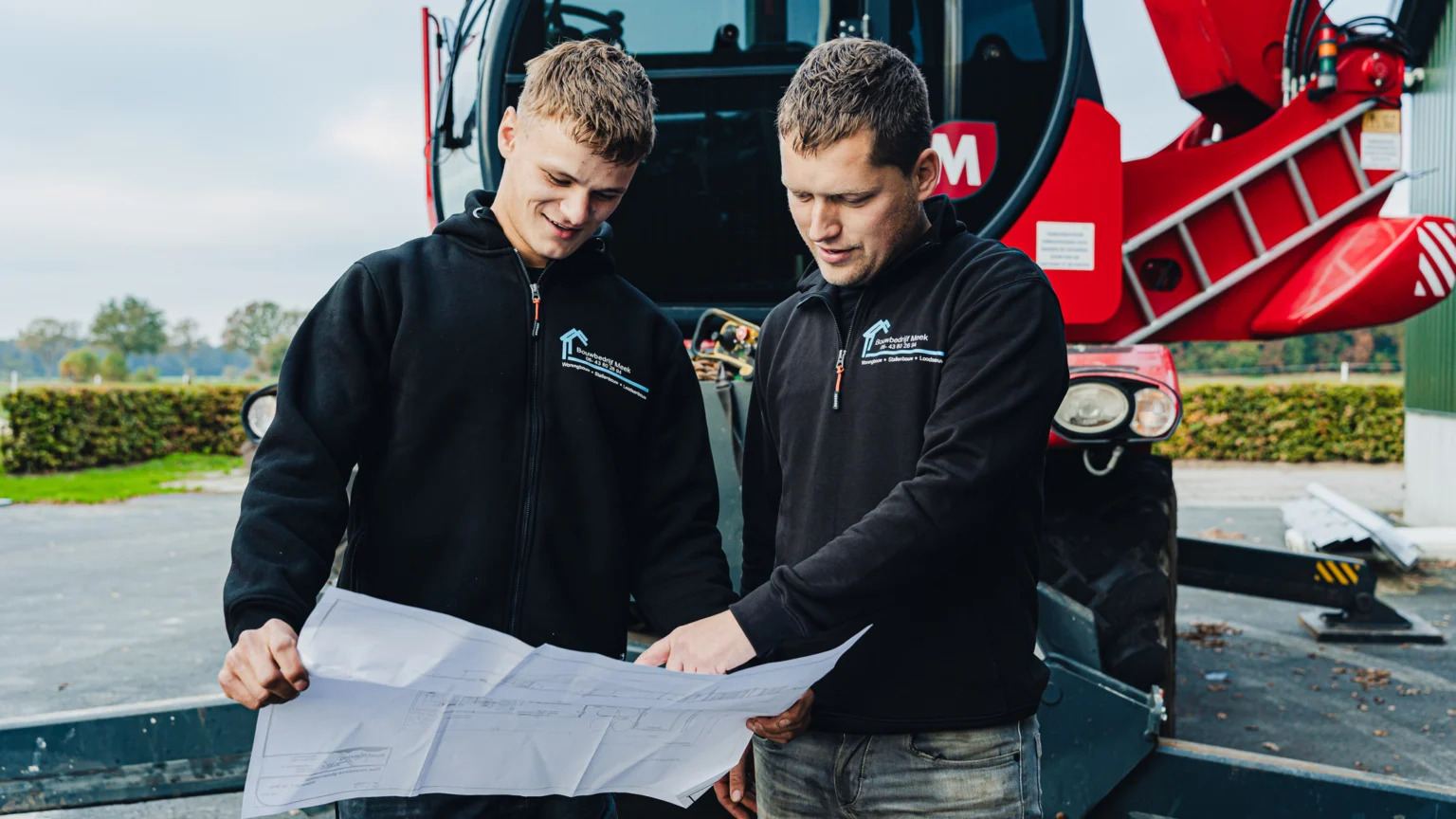 Twee medewerkers van Bouwbedrijf Meek bekijken een bouwtekening