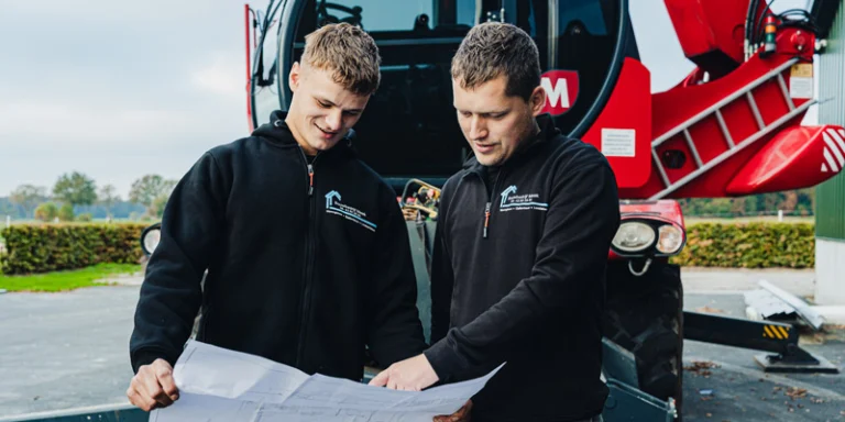Twee medewerkers van Bouwbedrijf Meek bekijken een bouwtekening